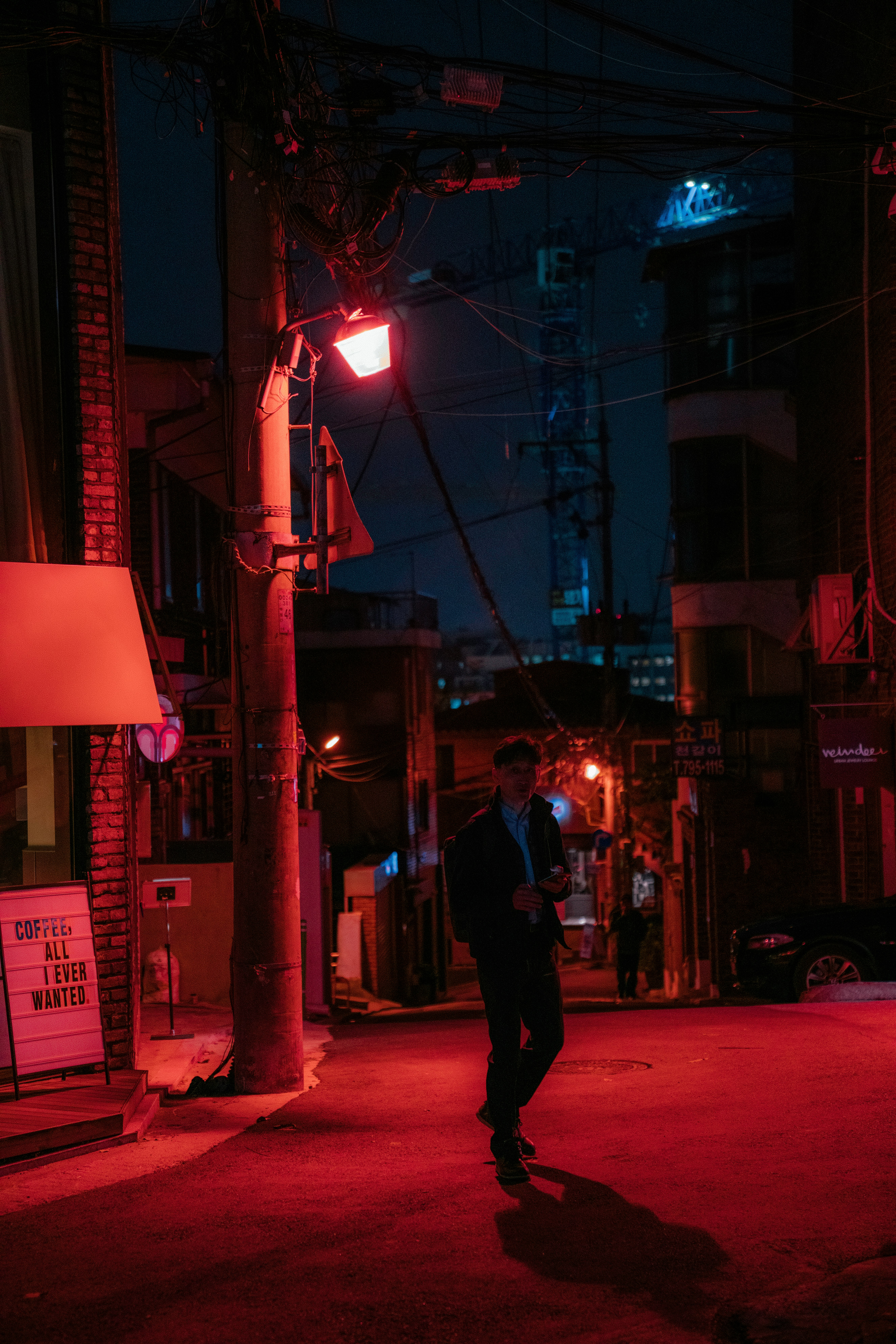 man in black jacket and pants walking on street during night time